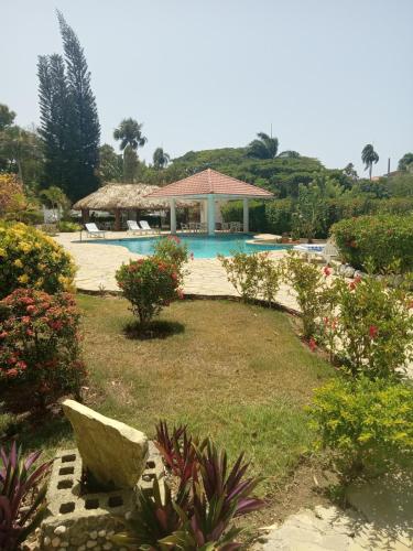 a garden with a swimming pool and a resort at Tropical Optimal Tropicana Sur in Sosúa