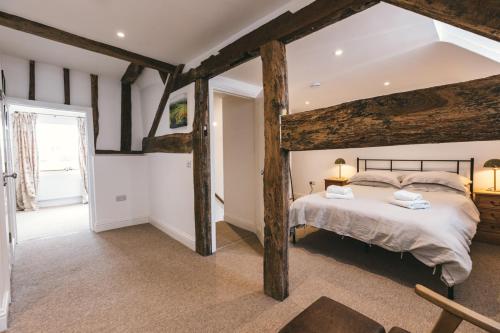 a bedroom with a large bed and wooden beams at Ludlow Escapes - Ludlow Town Centre Apartments in Ludlow