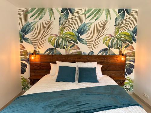 - une chambre avec un lit et un mur orné de plantes dans l'établissement Domaine de Couilleuse, à Saint-Laurent-Nouan
