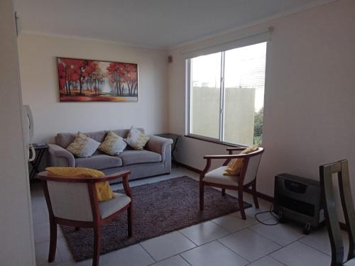 sala de estar con sofá y mesa en Casa Condominio Los Robles II Púcon, en Pucón