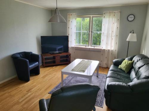 sala de estar con sofá, mesa y TV en Stugby Marieke - Skärvången en Föllinge