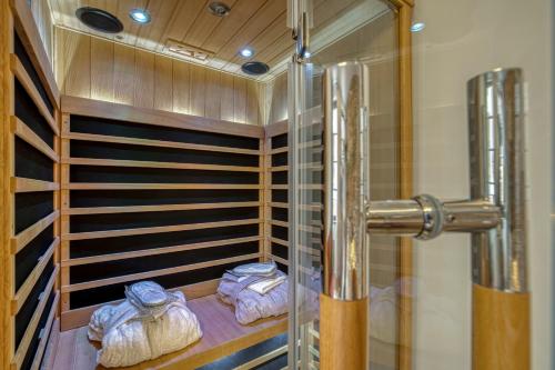 uma cabina de duche ao nível do chão com toalhas num quarto em Le Baroque clim et sauna em Annecy