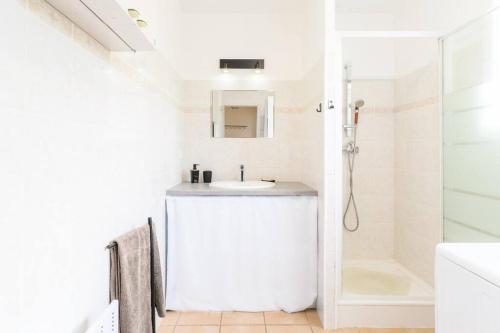 a white bathroom with a sink and a shower at New Charmante maison proche océan in Biscarrosse