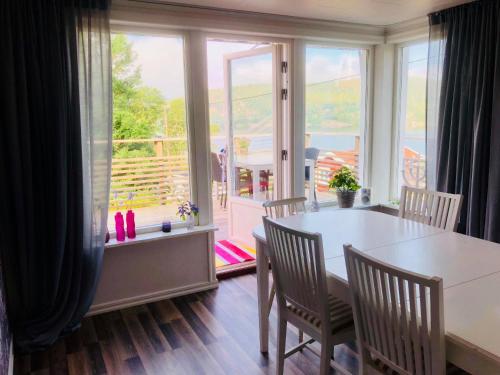 d'une salle à manger avec une table, des chaises et une fenêtre. dans l'établissement Lovely holiday house by a beautiful lake!, à Svenshögen