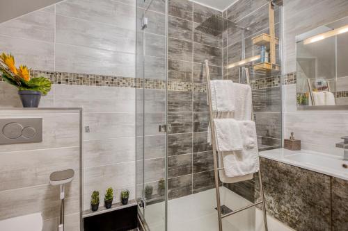 a bathroom with a glass shower and a sink at Passage des bains in Annecy