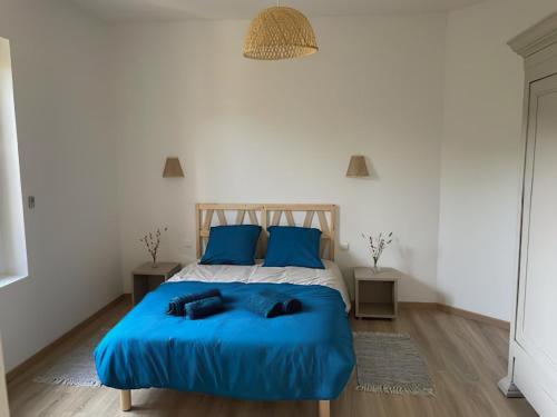 a bedroom with a bed with blue sheets and blue pillows at Maison La Vielmuroise in Vielmur-sur-Agout