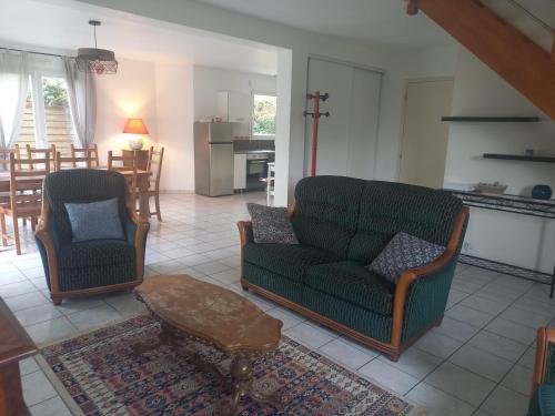 - un salon avec deux chaises, un canapé et une table dans l'établissement Binic 700m de la plage 4 chambres, jardin, linge, wifi, à Binic