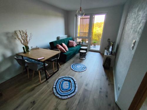a living room with a green couch and a table at Apartament Leśna Mandala in Augustów