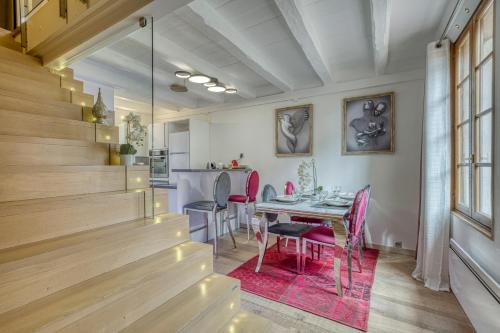 une salle à manger avec une table et des chaises roses dans l'établissement Passage des bains, à Annecy
