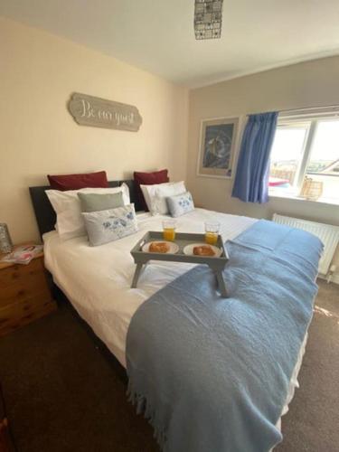 a bedroom with a bed with a tray of food on it at Salcombe View in Kingsbridge