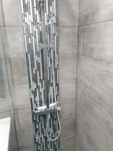 La salle de bains est pourvue d'une douche avec une structure métallique. dans l'établissement FRONTIÈRE MONACO, à Beausoleil