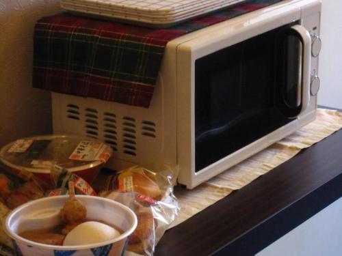水戸市にあるArC LIFESTYLE SPACE & HOTEL - Vacation STAY 73238vの食器入りカウンターの電子レンジ