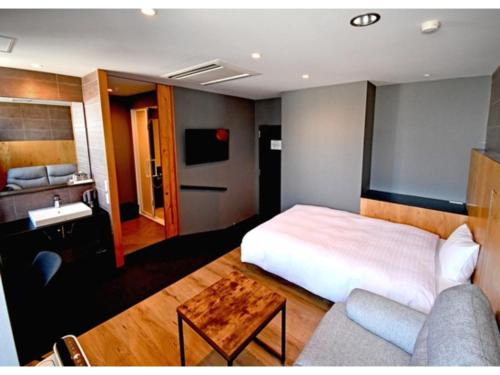 水戸市にあるArC LIFESTYLE SPACE & HOTEL - Vacation STAY 73240vのベッドとソファのあるホテルの部屋
