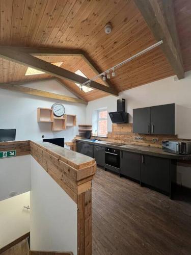 a large kitchen with wooden ceilings and a clock on the wall at 1 bedroom flat Bristol centre in Bristol