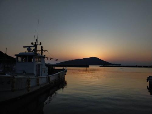 鳥羽市にあるMinpaku Togenkyo 2 - Vacation STAY 15096の夕日を背景に水中に座る船
