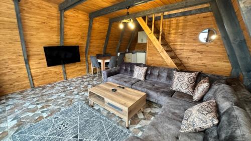 - un salon avec un canapé et une télévision dans l'établissement Kartal Yuvası Tatil Köyü, à Trabzon