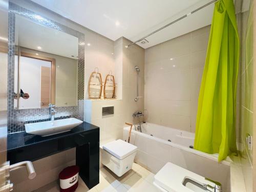 a bathroom with a sink and a toilet and a tub at Corail Apart Golfique -Prestigia in Marrakech