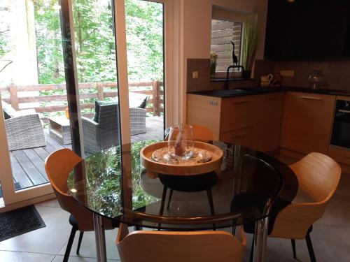 a kitchen with a glass table and some chairs at Le Héron ( Gîte ) in Blaimont