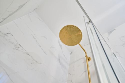 La salle de bains est pourvue d'un pommeau de douche et de murs en marbre blanc. dans l'établissement Appartement cosy au centre de Lille, à Lille