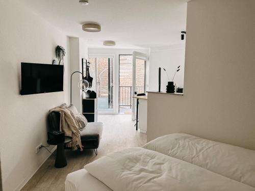 a bedroom with a bed and a desk and a television at Düsseldorf Boutique-Style Studioapartments in Düsseldorf