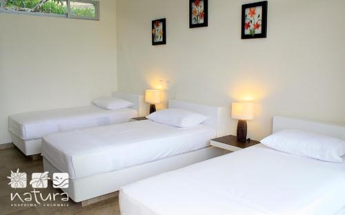 two beds in a hotel room with two lamps at Natura Reservado - Hoteles Natura in Anapoima