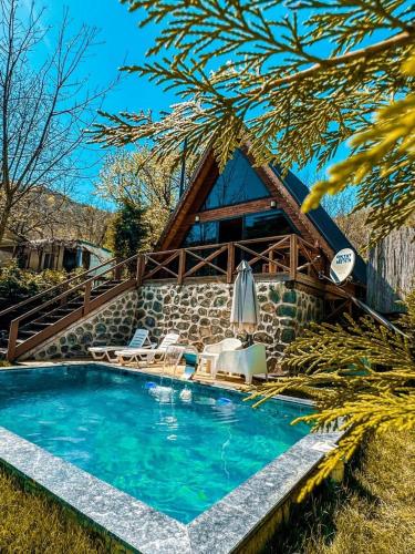a swimming pool in front of a house at MERCE BUNGALOV in Sakarya