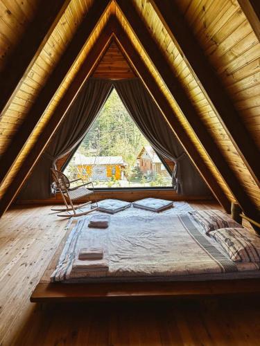 łóżko w pokoju z dużym oknem w obiekcie MERCE BUNGALOV w mieście Sakarya