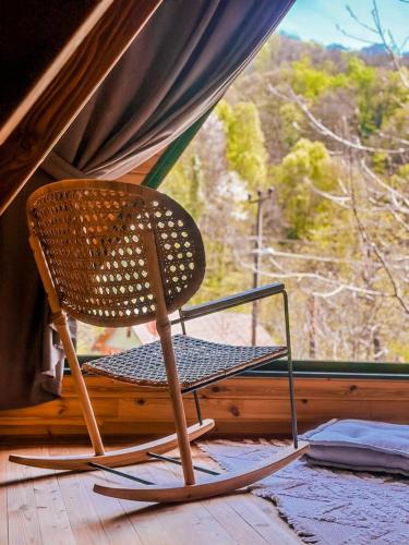 una silla de mimbre sentada frente a una ventana en MERCE BUNGALOV, en Sakarya