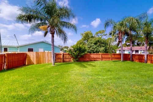 a yard with a fence and a palm tree at Glenwood Hideaway in Port Saint Lucie