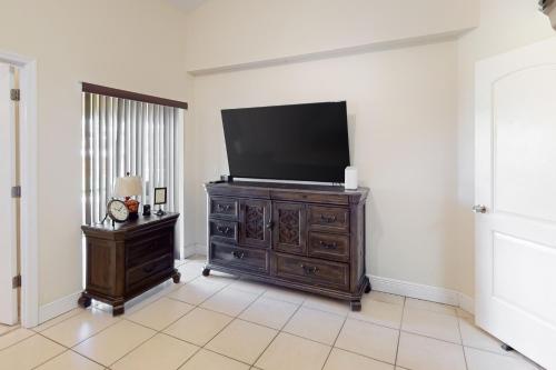 a living room with a flat screen tv on a dresser at Glenwood Hideaway in Port Saint Lucie