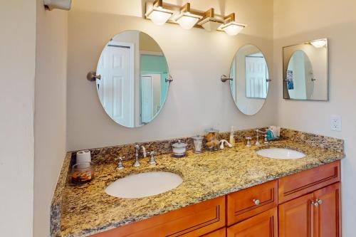 a bathroom with two sinks and two mirrors at Glenwood Hideaway in Port Saint Lucie