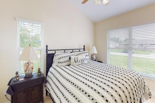 a bedroom with a bed with a black and white comforter at Glenwood Hideaway in Port Saint Lucie