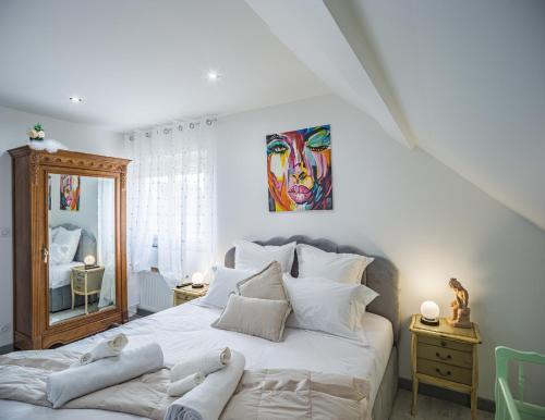 Saint-André-les-VergersにあるLe Flamboyant - Confort & Rareté - Premiumのベッドルーム1室(壁に絵画が描かれた白い大型ベッド1台付)