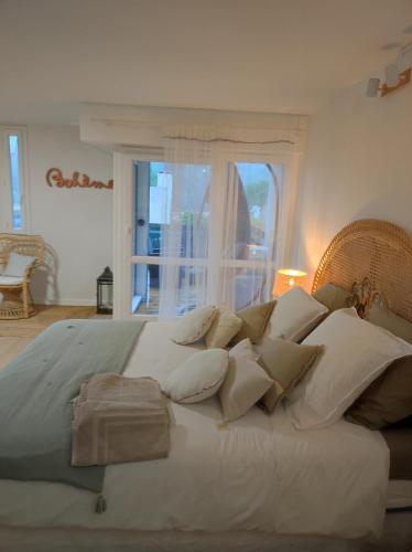 Elle comprend un grand lit blanc avec des oreillers et une fenêtre. dans l'établissement Mes'anges, aux Baux-de-Provence