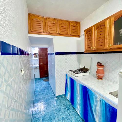 a kitchen with blue and white tiles and a stove at Oldtown House in Chefchaouene