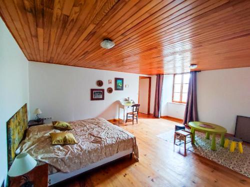 1 dormitorio con cama y techo de madera en Gîte de ville appartement Location de vacance - St-Flour - 6-8 Personnes dans le Cantal, en Saint-Flour