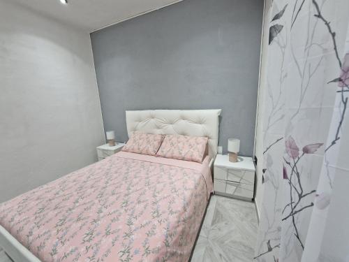 a bedroom with a pink bed and two night stands at La Maddalena Holiday Home in La Maddalena