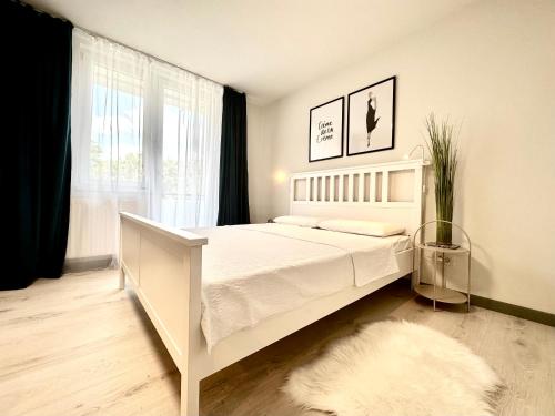 a bedroom with a white bed and a window at Chic Studio in Timişoara
