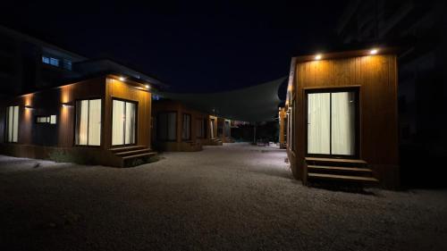 une rangée de bâtiments la nuit avec des lumières sur eux dans l'établissement Tiny House Sitesi, à Alanya