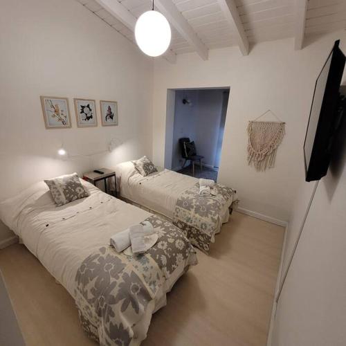 1 dormitorio con 2 camas y TV. en TADASANA HOUSE en Ushuaia