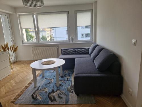 a living room with a couch and a table at Apartament Czemunie in Gdynia
