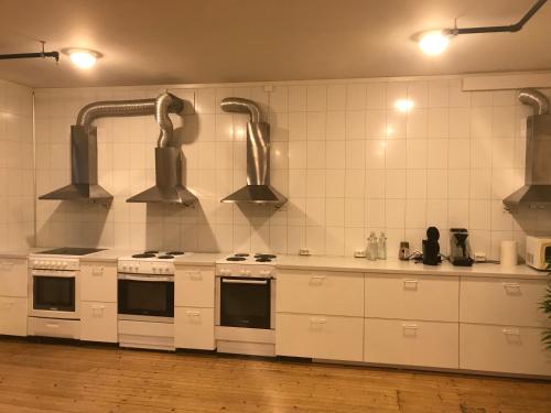 a kitchen with white counters and white appliances at Leirvik Vandrehjem in Leirvik