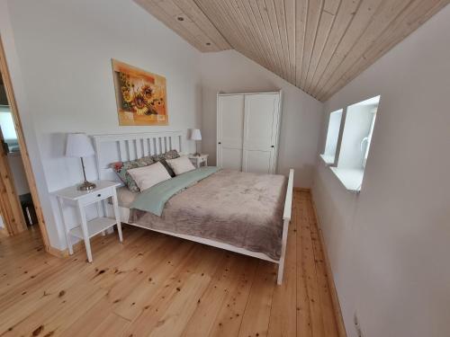 1 dormitorio con 1 cama y suelo de madera en Scheune in Ostseenähe auch mit Pferd, en Ducherow