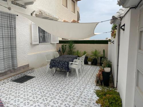 a patio with a table and chairs on a tiled floor at Casa de la playa in Torrevieja