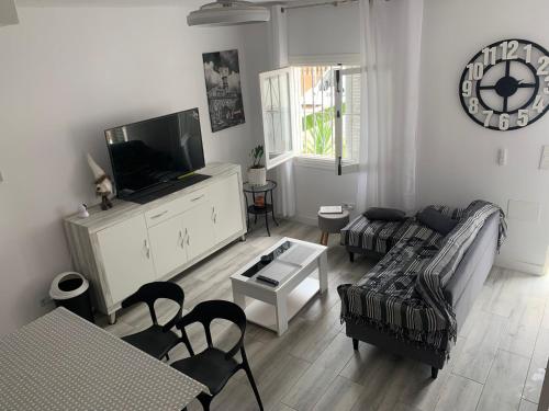 a living room with a couch and a tv at Casa de la playa in Torrevieja