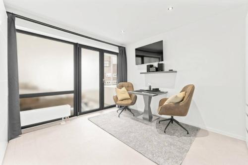 a living room with a table and two chairs at HH 05 Modernes Apartment am Winterhuder Marktplatz in Hamburg