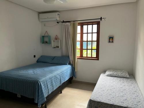 1 dormitorio con 2 camas y ventana en Apartamento em Lençóis, Cond. Vivendas do Serrano 105 en Lençóis
