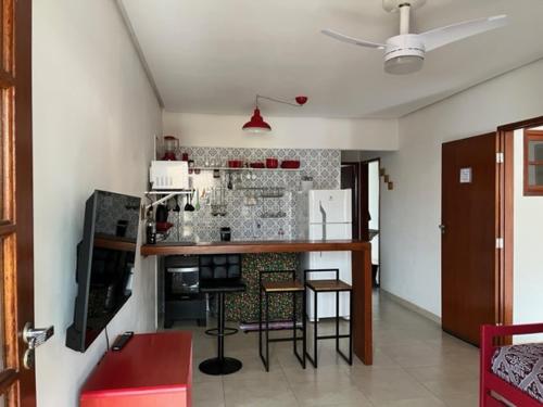 a kitchen with a counter and some chairs in a room at Apartamento em Lençóis, Cond. Vivendas do Serrano 105 in Lençóis