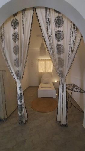 a bedroom with a bed and a curtain at Villa kenza in Houmt Souk