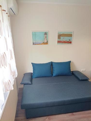 Bett mit blauen Kissen in einem Zimmer in der Unterkunft SaraHome3 Center in Szeged